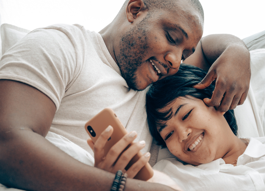 Couple smiling together while looking at phone