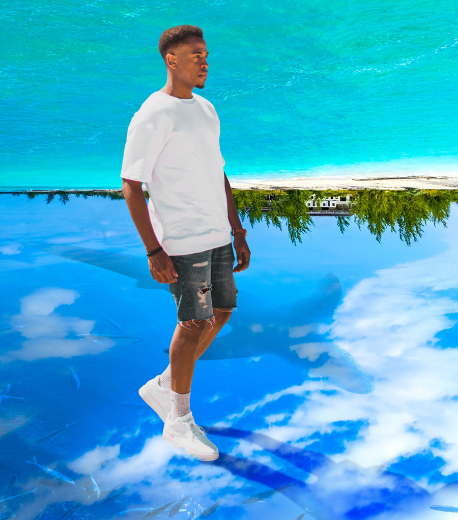 man walking with a flipped background so that he's walking on the sky with sharks and fish below him