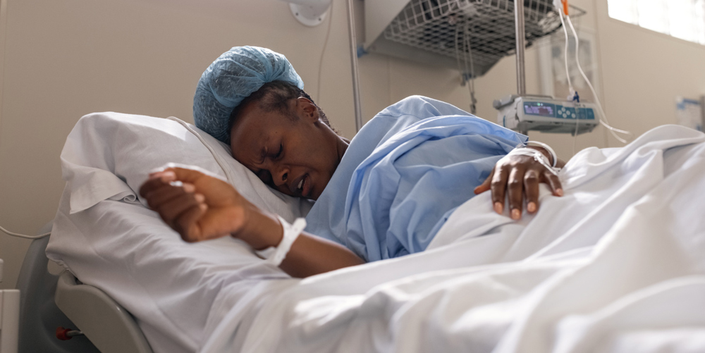 woman in discomfort during child birth in a hospital bed