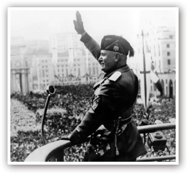 Benito Mussolini stands on a balcony, holding his hand up to a sea of people in a cities streets