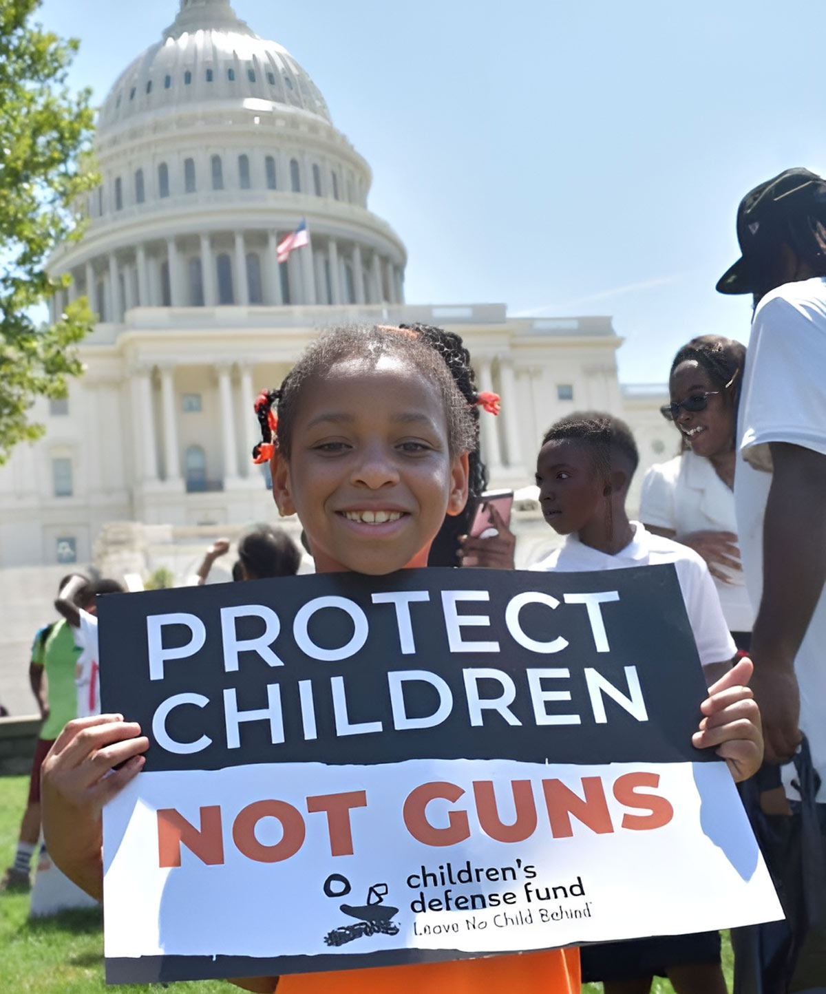 Young girl holding sign that read 'Protect Children Not Guns'