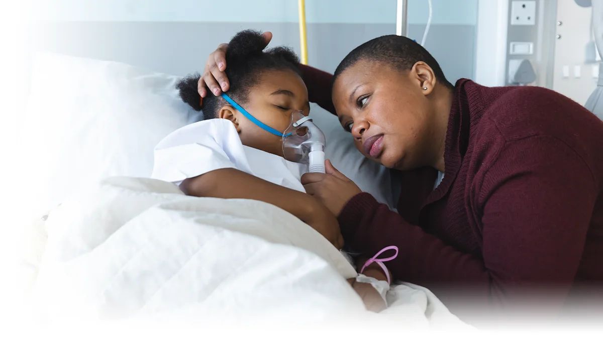 mother watching over daughter in a hospital bed