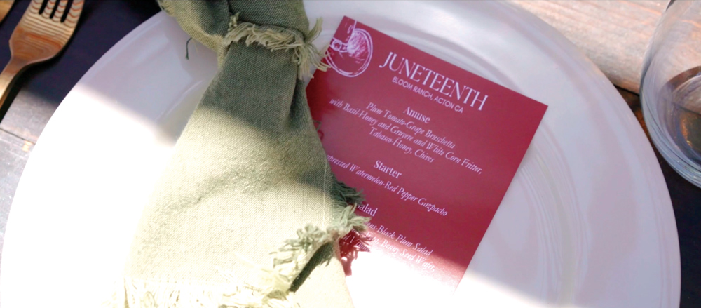 A dining setup with a white plate, a pale green napkin, and a red menu card.