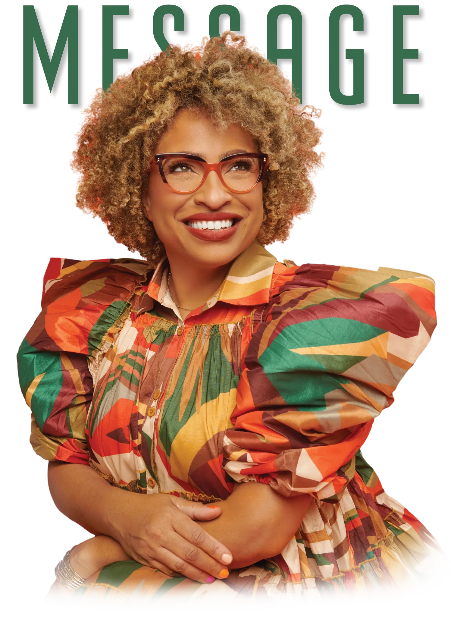Portrait of a smiling woman with curly hair and red-framed glasses, wearing a vibrant multicolored dress with puffed sleeves, posed in front of the word “MESSAGE” in green uppercase letters.