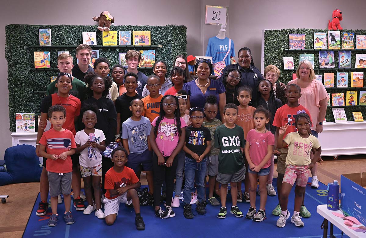 Oticia Childers posing with a group of children and community members