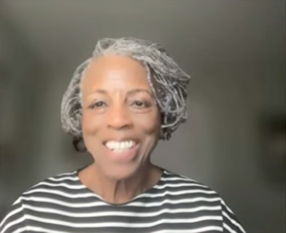 Headshot of a smiling woman with salt-and-pepper hair.