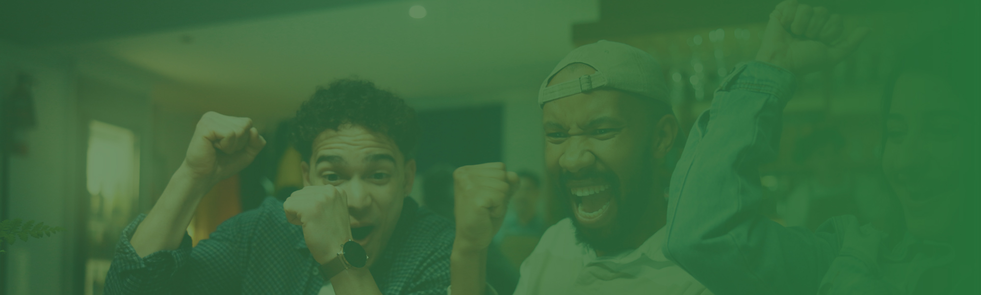 Green-tinted photo of three people cheering and celebrating with raised fists.