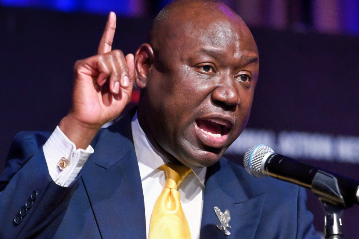 Close-up of civil rights attorney Ben Crump speaking into a microphone with his index finger raised.